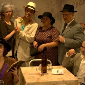 Grupo de atores em cena, diante da plateia