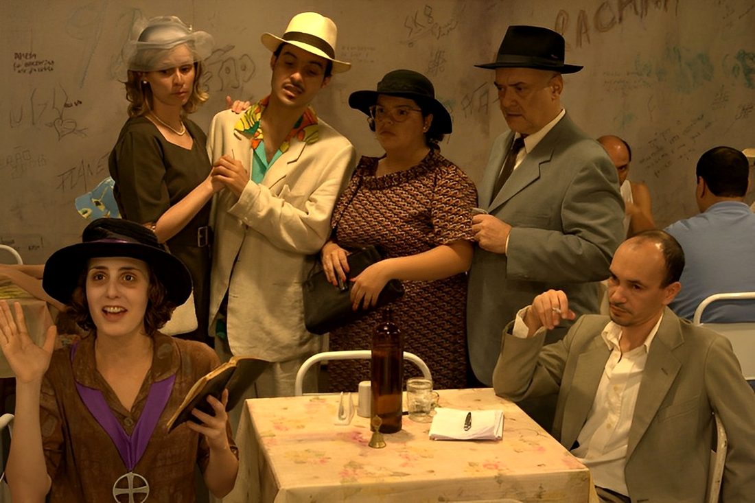 Grupo de atores em cena, diante da plateia